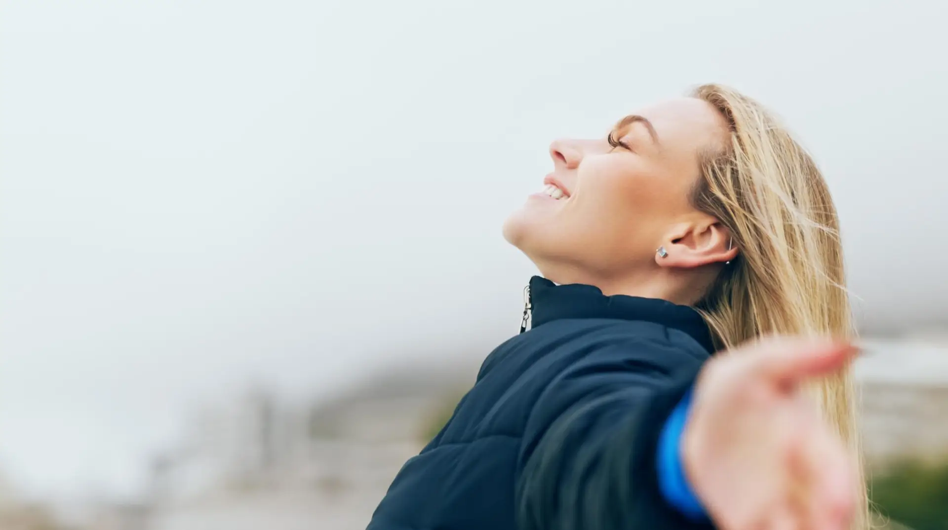 Happy woman, outdoor freedom arms out in wind, breathe fresh air or purpose, happiness and motivation, peace and dream, calm or hope. Smile lady, optimism and relax in nature, wellness or mindfulness